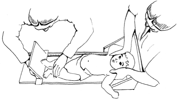 Measurer and assistant working together to position child
